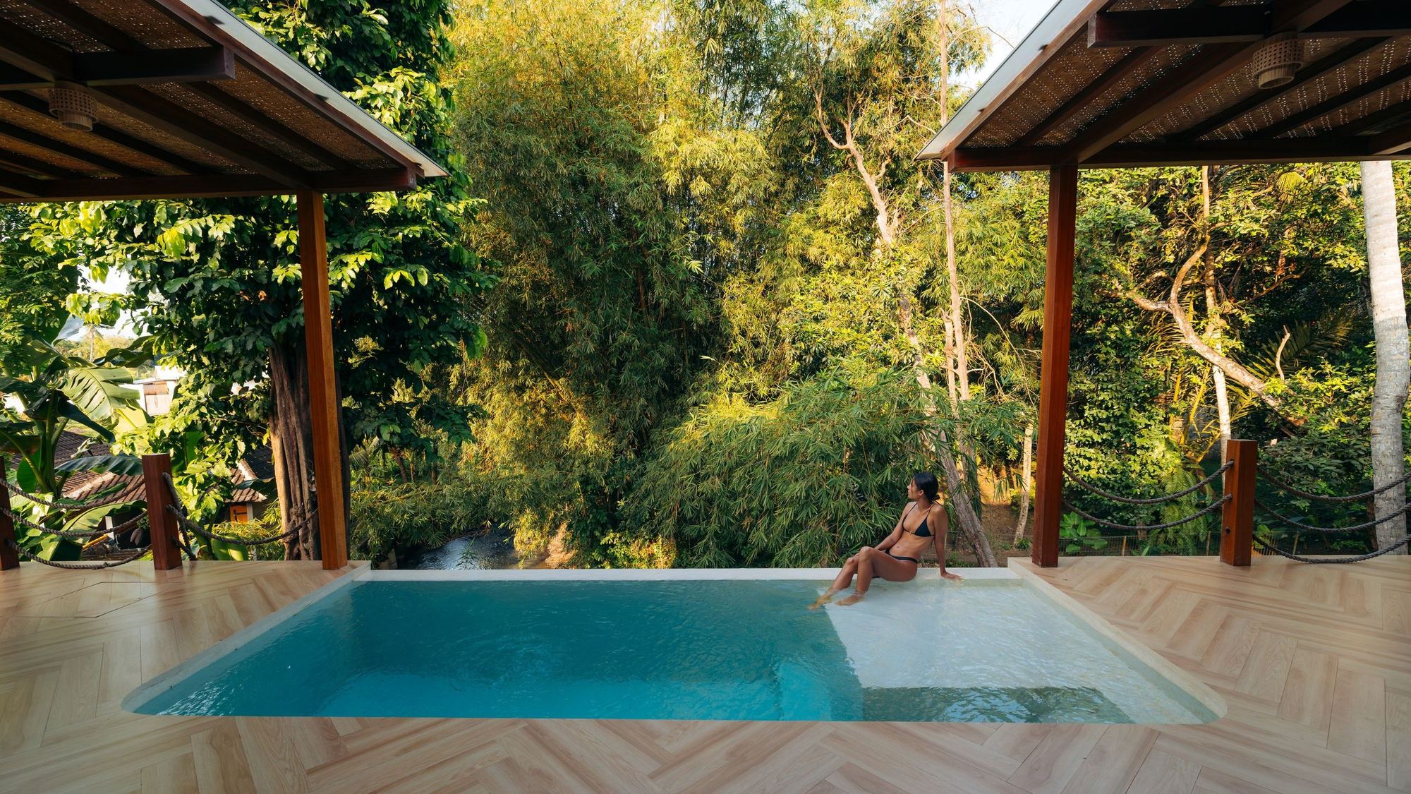 Pool and deck at a Bali villa, looking into the trees